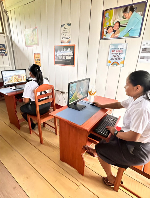 donated-computers-with-aoa-students two peruvian children using their first school computer set up